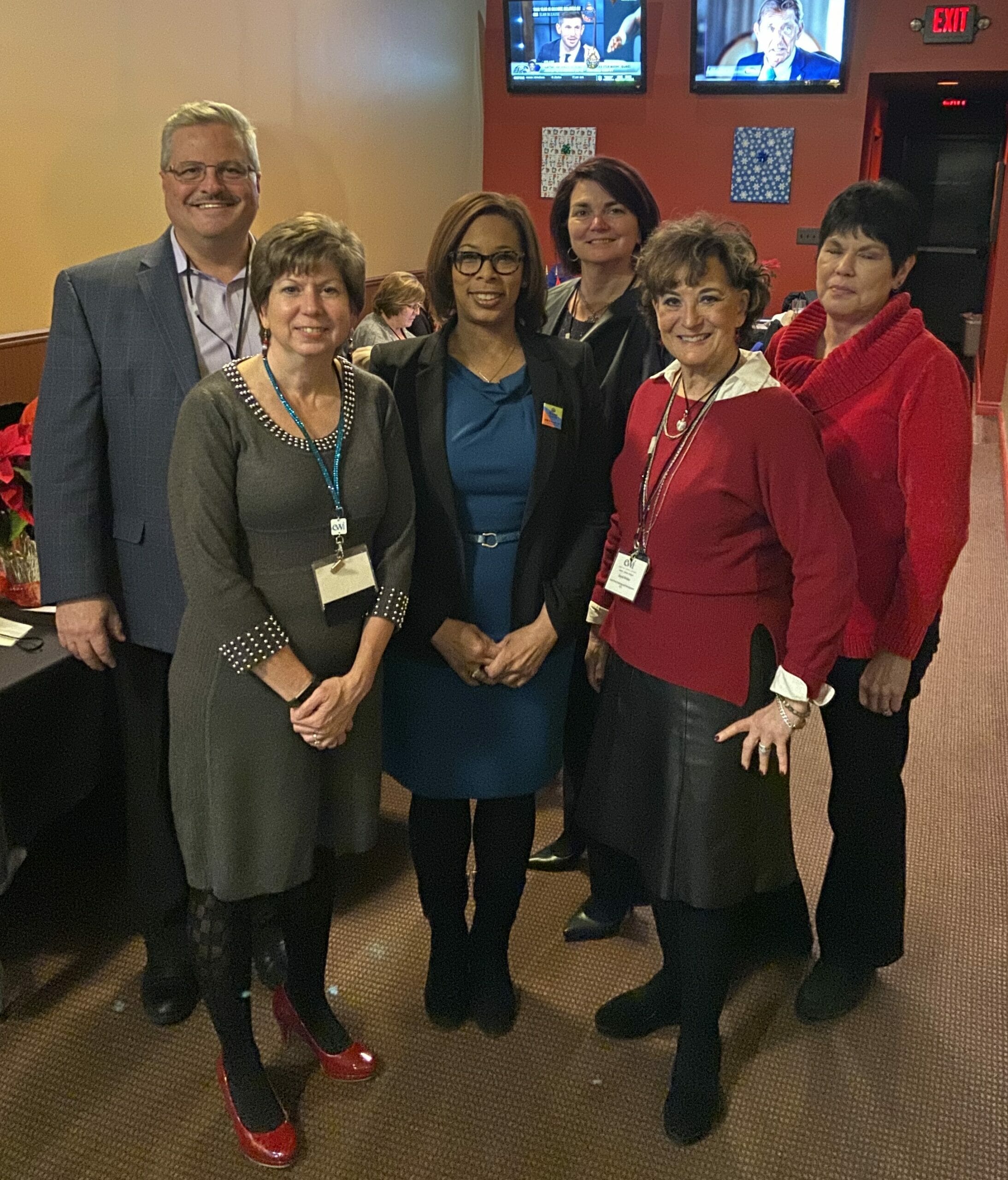 A group of 6 people standing in a restaurant, smiling at the camera. | Clinical Services